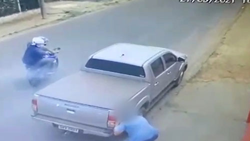 divulgação - Homem sofre tentativa de homicídio de dupla em moto e escapa após se esconder atrás de caminhonete (Foto: Câmeras de Segurança)