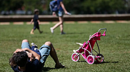 Pai segura no colo seu filho em parque no Brasil